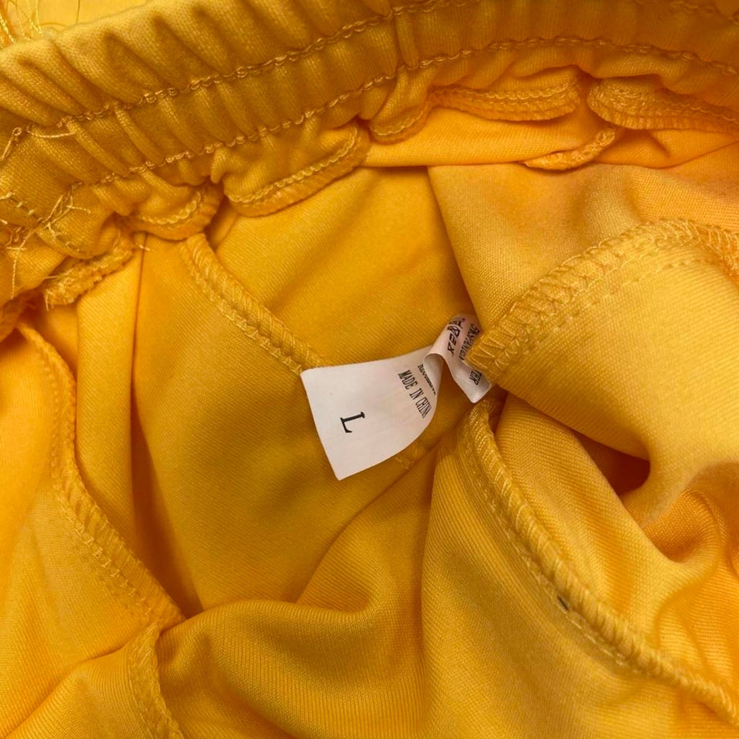 Yellow feathered sweatpants with fringe